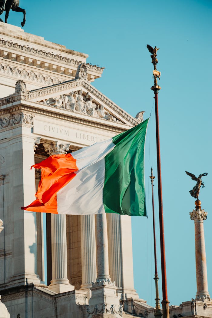 The Irish flag waves gracefully in the breeze at a historic landmark.